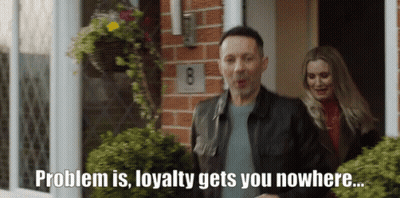 A Man And A Woman Are Standing In Front Of A House With The Number 8 On The Brick Wall GIF