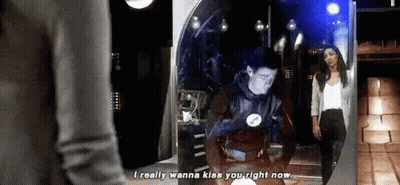 A Man And A Woman Are Standing In Front Of A Mirror . GIF