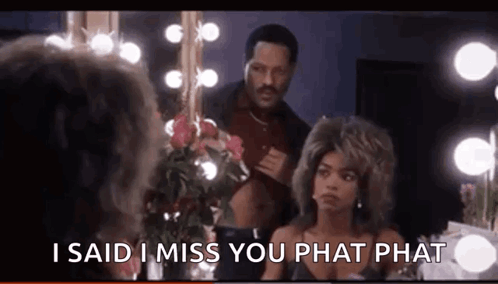 A Man And A Woman Are Standing In Front Of A Mirror . The Man Is Talking To The Woman . GIF