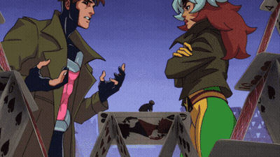 A Man And A Woman Are Standing In Front Of A Pile Of Playing Cards One Of Which Has The Number 4 On It GIF