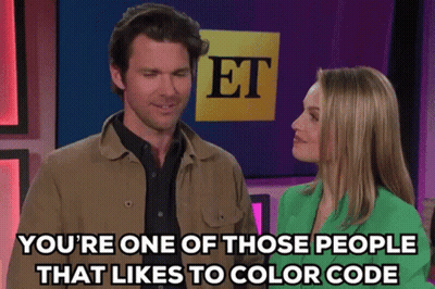 A Man And A Woman Are Standing In Front Of A Sign That Says Et On It GIF