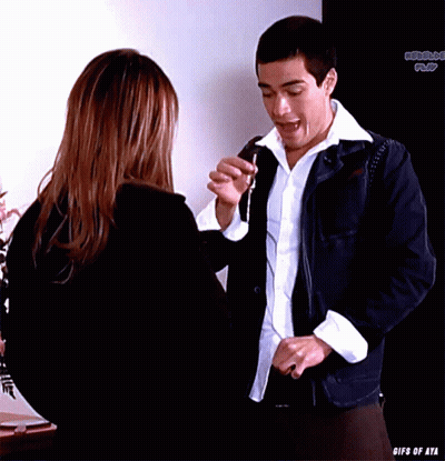 A Man And A Woman Are Standing In Front Of A Sign That Says ' Gifs Of Aya ' GIF
