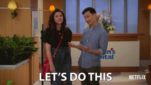 A Man And A Woman Are Standing In Front Of A Sign That Says ' Let 'S Do This ' GIF