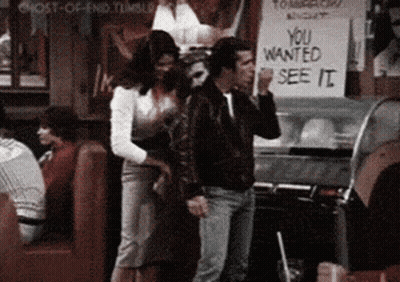 A Man And A Woman Are Standing In Front Of A Sign That Says " You Wanted See It " GIF