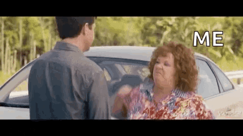 A Man And A Woman Are Standing Next To A Car And The Woman Is Yelling At The Man . GIF