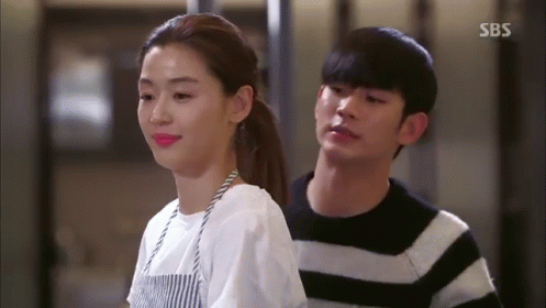 A Man And A Woman Are Standing Next To Each Other . GIF