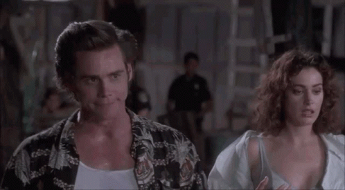 A Man And A Woman Are Standing Next To Each Other . GIF