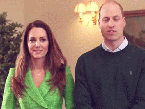 A Man And A Woman Are Standing Next To Each Other GIF