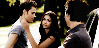 A Man And A Woman Are Standing Next To Each Other And A Man Is Touching The Woman 'S Neck GIF