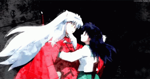 A Man And A Woman Are Standing Next To Each Other And Hugging Each Other . GIF