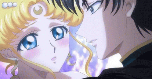 A Man And A Woman Are Standing Next To Each Other And Kissing . GIF