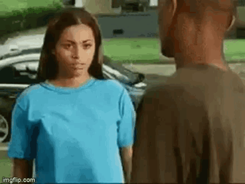A Man And A Woman Are Standing Next To Each Other And Looking At Each Other . GIF