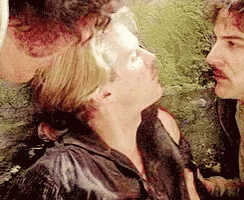 A Man And A Woman Are Standing Next To Each Other And Looking At Each Other . GIF
