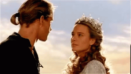 A Man And A Woman Are Standing Next To Each Other And Looking At Each Other . GIF