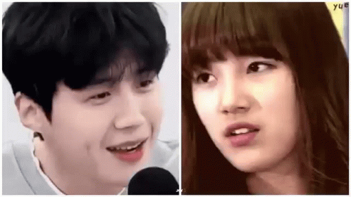 A Man And A Woman Are Standing Next To Each Other And Smiling At Each Other . GIF