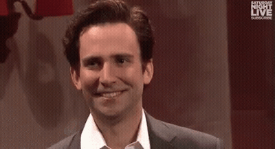A Man And A Woman Are Standing Next To Each Other And Smiling At The Camera . GIF
