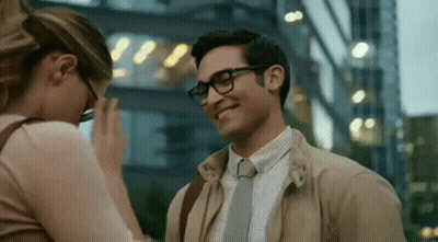 A Man And A Woman Are Standing Next To Each Other And Smiling . GIF