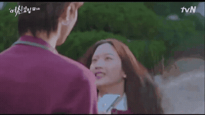 A Man And A Woman Are Standing Next To Each Other And Smiling . The Woman Is Wearing A School Uniform . GIF