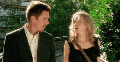 A Man And A Woman Are Standing Next To Each Other And Talking GIF