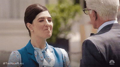 A Man And A Woman Are Standing Next To Each Other And Talking To Each Other . GIF