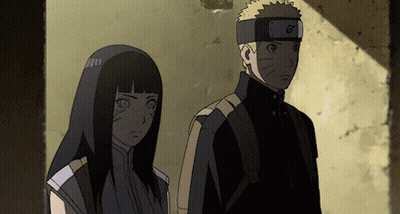 A Man And A Woman Are Standing Next To Each Other And The Man Has A Headband With The Letter G On It GIF