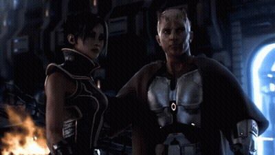 A Man And A Woman Are Standing Next To Each Other And The Man Has An O On His Chest GIF