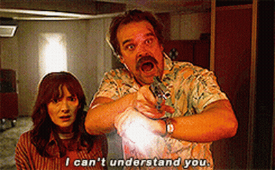 A Man And A Woman Are Standing Next To Each Other And The Man Is Pointing At The Woman . GIF