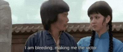 A Man And A Woman Are Standing Next To Each Other And The Man Is Saying I Am Bleeding Making Me The Victor GIF