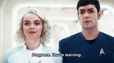 A Man And A Woman Are Standing Next To Each Other And The Man Is Saying Progress You 'Re Learning GIF