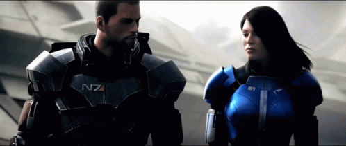 A Man And A Woman Are Standing Next To Each Other And The Man 'S Armor Says N7 On It GIF