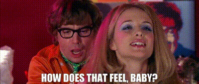A Man And A Woman Are Standing Next To Each Other And The Woman Is Asking The Man How Does That Feel Baby . GIF
