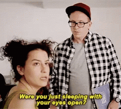 A Man And A Woman Are Standing Next To Each Other And The Woman Is Asking The Man If He Is Sleeping With Her Eyes Open GIF