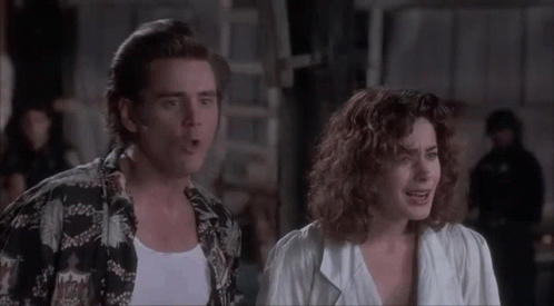 A Man And A Woman Are Standing Next To Each Other And The Woman Is Making A Face . GIF