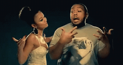 A Man And A Woman Are Standing Next To Each Other And The Woman Is Pointing At The Man GIF