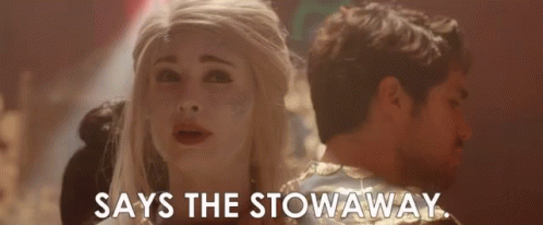 A Man And A Woman Are Standing Next To Each Other And The Woman Is Saying `` Says The Stowaway '' . GIF