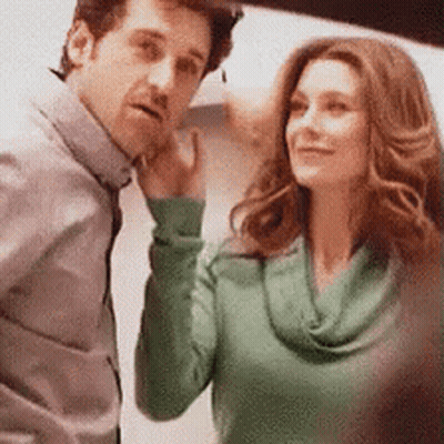 A Man And A Woman Are Standing Next To Each Other And The Woman Is Wearing A Green Shirt GIF