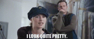 A Man And A Woman Are Standing Next To Each Other And The Woman Is Wearing A Police Hat . GIF