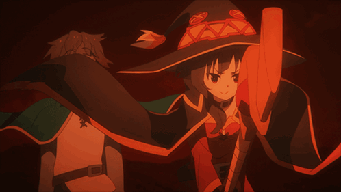 A Man And A Woman Are Standing Next To Each Other And The Woman Is Wearing A Red Witch Hat GIF