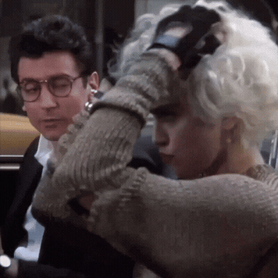 A Man And A Woman Are Standing Next To Each Other And The Woman Is Wearing Gloves GIF