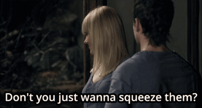A Man And A Woman Are Standing Next To Each Other And The Woman Says " Don T You Just Wanna Squeeze Them " GIF