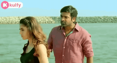 A Man And A Woman Are Standing Next To Each Other By The Water . GIF