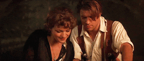 A Man And A Woman Are Standing Next To Each Other . GIF