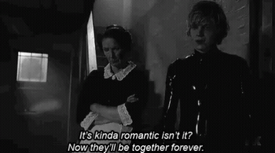 A Man And A Woman Are Standing Next To Each Other In A Black And White Photo . GIF
