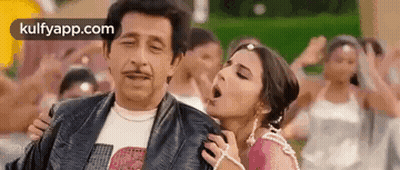 A Man And A Woman Are Standing Next To Each Other In A Crowd Of People . GIF