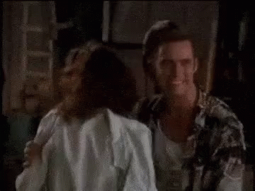 A Man And A Woman Are Standing Next To Each Other In A Dark Room GIF