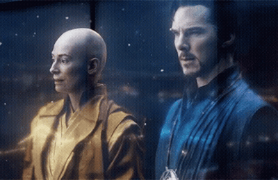 A Man And A Woman Are Standing Next To Each Other In A Dark Room GIF