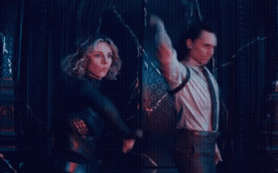 A Man And A Woman Are Standing Next To Each Other In A Dark Room Holding Swords . GIF