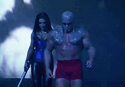 A Man And A Woman Are Standing Next To Each Other In A Dark Room GIF