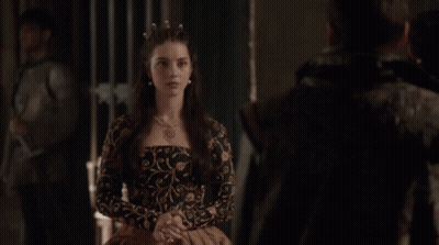 A Man And A Woman Are Standing Next To Each Other In A Dark Room . GIF