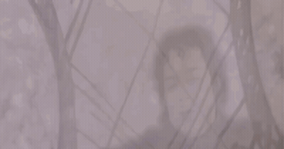 A Man And A Woman Are Standing Next To Each Other In A Foggy Room GIF